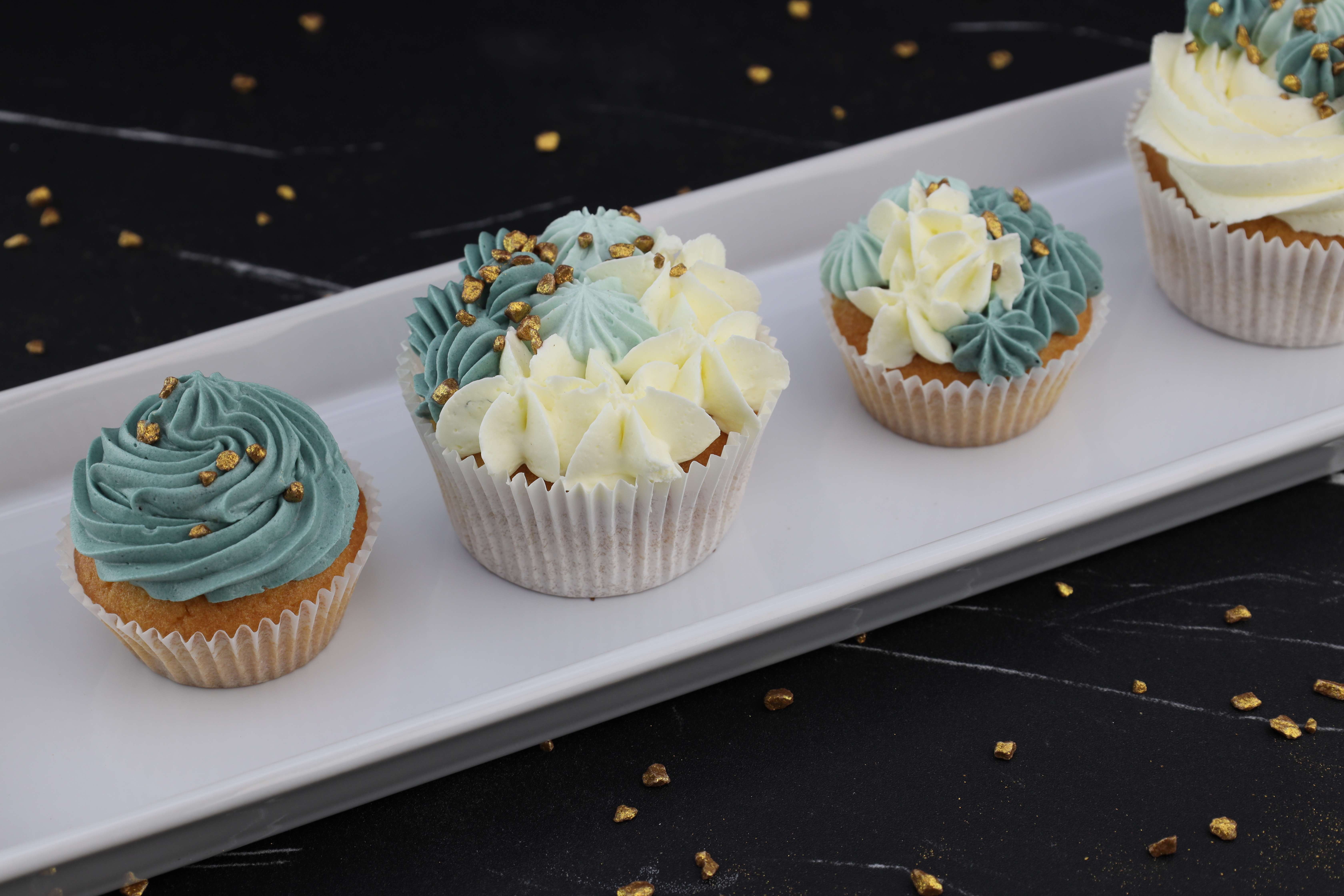 Köstlicher eukalyptusblauer und weißer Buttercreme muffins mit Goldzucker oben drauf. 
