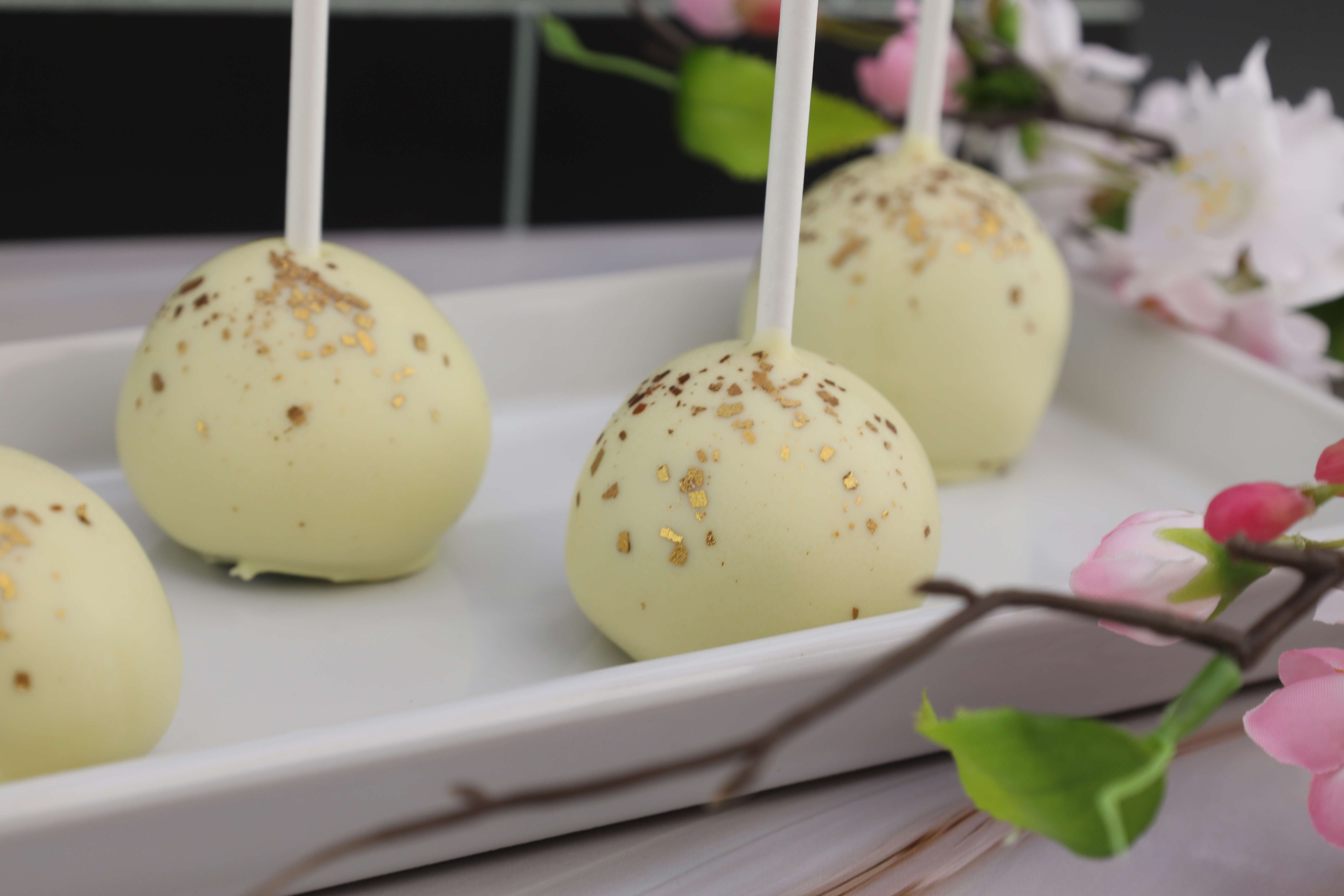 Leckere Cake Pops mit weißer Schokolade überzogen und mit essbarem Goldglitter verziert. 