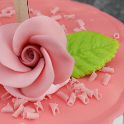 Rosa Kuchen mit Schokoladenrose und Marzipanblättern